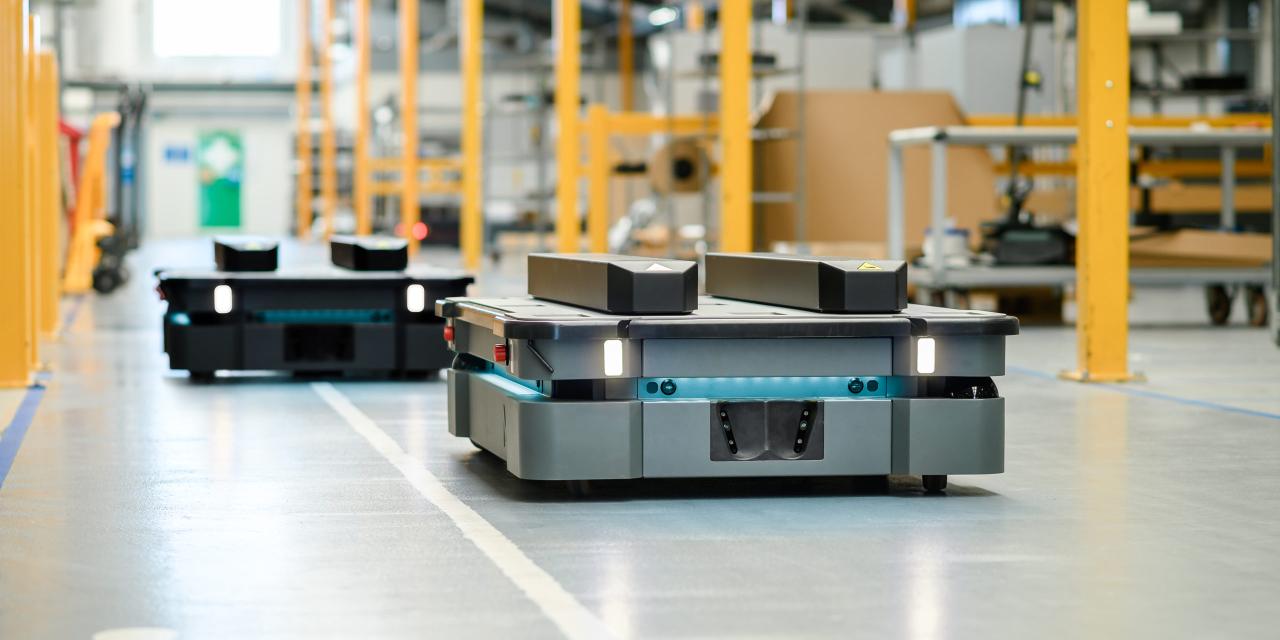 Autonomous robots transporting materials in a warehouse or factory.